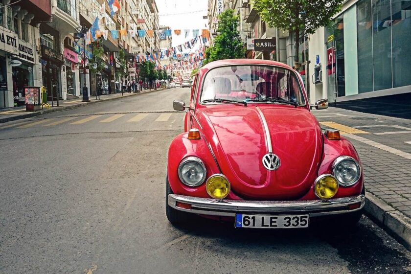 Volkswagen rossa parcheggiata, ideale per rappresentare il segmento delle utilitarie tedesche affidabili e accessibili