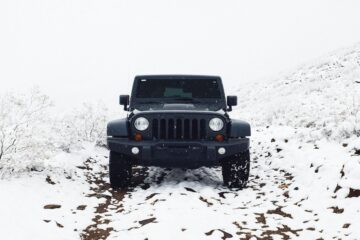 Auto SUV bianca a trazione integrale su strada di montagna coperta di neve