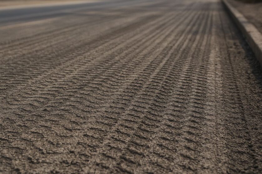 Dettaglio della strada fresata con superficie ruvida e strati d’asfalto rimossi
