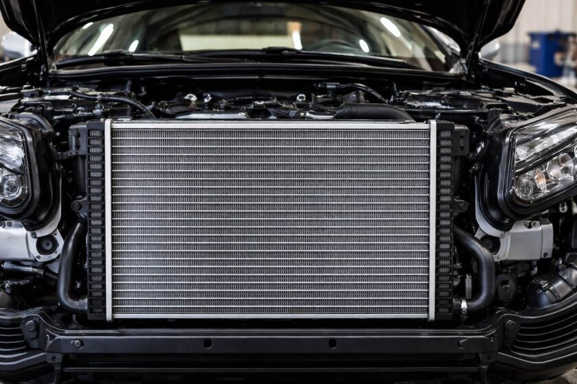 Dettaglio del radiatore auto nel vano motore con alette e condotti visibili