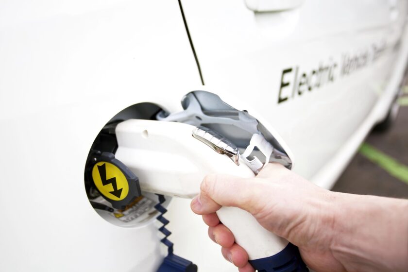 Auto elettrica collegata a una colonnina di ricarica in città