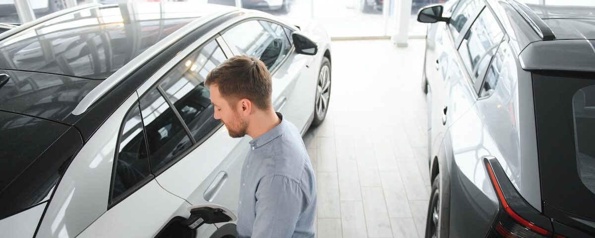 Persona che valuta l’acquisto di un’auto elettrica in concessionaria