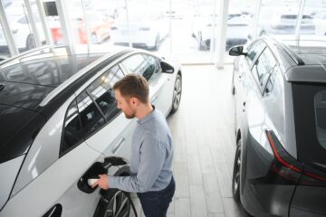 Persona che valuta l’acquisto di un’auto elettrica in concessionaria