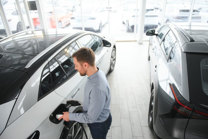 Persona che valuta l’acquisto di un’auto elettrica in concessionaria