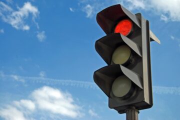 Auto ferma al semaforo rosso prima della linea di arresto in un incrocio urbano
