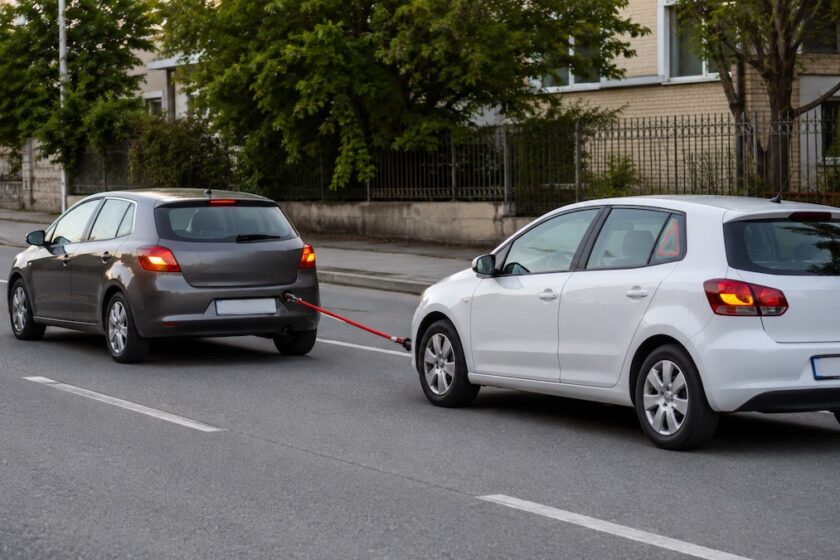 Automobile in avaria trainata con una fune rossa da un altro veicolo